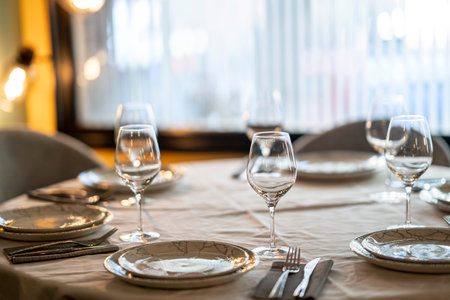 A shallow focus beautiful table setting with crockery and glasses for an event in the restaurantの写真素材