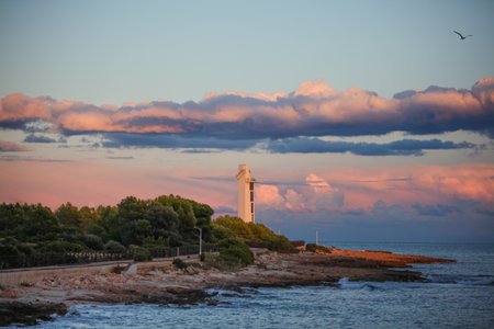 A beautiful view of a lighthouse by the sea at sunset in Alcossebre, Spainの写真素材