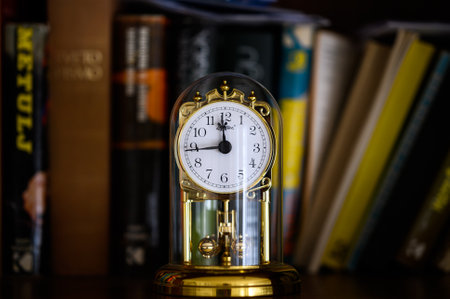 Old golden clock with books in the background