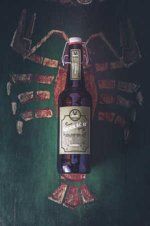 A vertical shot of a craft beer on the background of a painted lobster