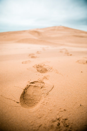 A vertical shot of footsteps on Dune of Pilat in Bordeaux, France