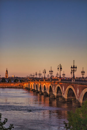 The Bordeaux river bridge with St Michel cathedral during the sunset in Franceの写真素材