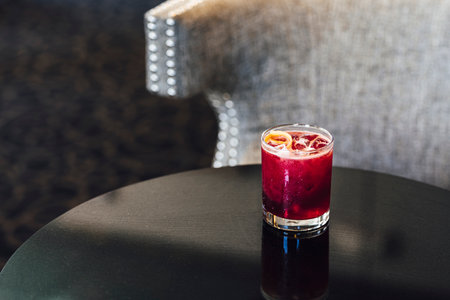 This deeply purple craft cocktail gets the intense color from infused rose hips. Garnished with a lemon twist, this drink is perfect for happy hour.の写真素材
