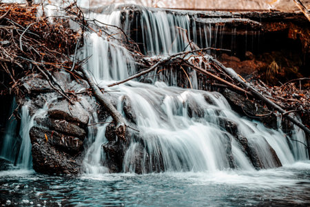 A scenic view of a waterfall in the woods in Golden Ponds Park