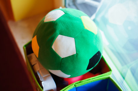 A closeup shot of a colorful plush ball on a windowsillの写真素材