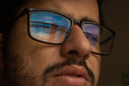 A portrait of a Brazilian male with glasses on a dark backgroundの写真素材