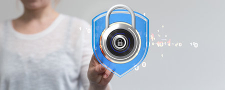 A shallow focus shot of a human hand holding a padlock - cybersecurity, digital information protectionの写真素材