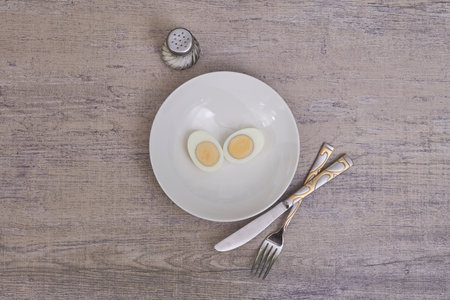 A top view shot of boiled eggs on a white plate in a kitchen