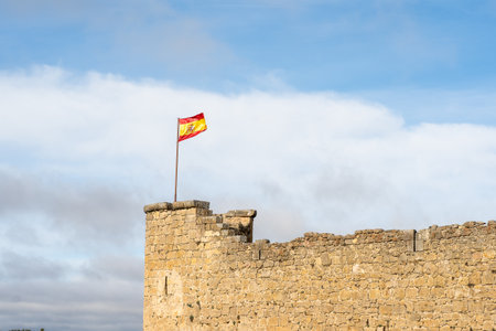 The Spanish flag over an ancient buildingの写真素材