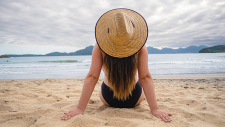 woman with typical brazilian cap looking at the beach on a cloudy day Brazil beach