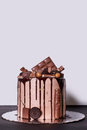A vertical shot of a tasty cake decorated with chocolate on the black surface