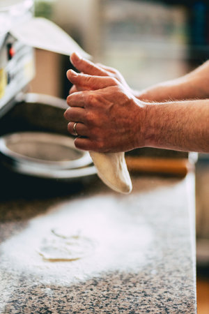 A closeup of a man preparing a pizza from doughの写真素材