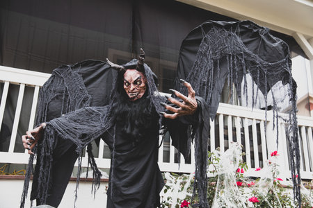 A decorative scary demon figure against a house ready for Halloween
