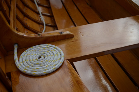 A white rope with yellow spots on a wooden surface