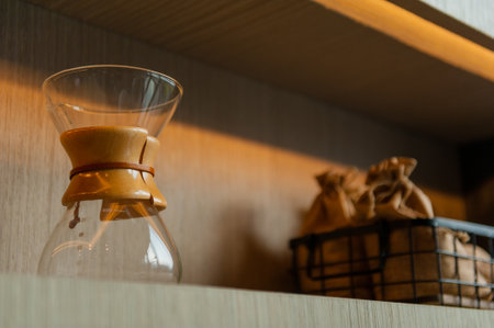 A closeup of a glass coffee maker on a shelfの写真素材