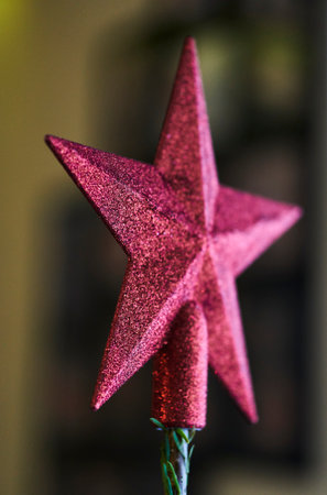A closeup of a pink star on a christmas tree