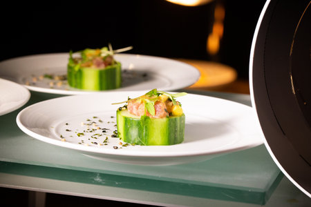 A closeup shot of plates with gourmet dishes with cucumberの写真素材