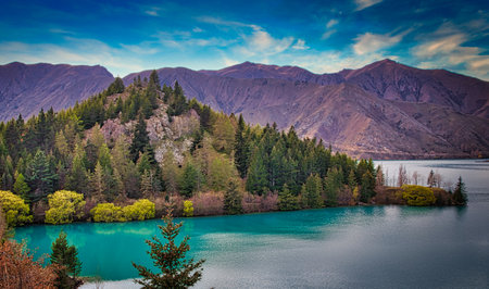 A beautiful view of a mountain with a rock covered with green in the seaの写真素材