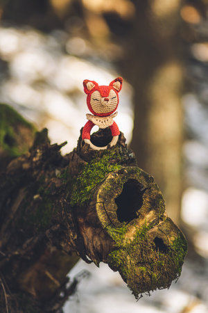 A closeup of a handmade fox toy for from wood and wool on a treeの写真素材