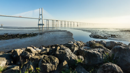 A beautiful view of a bridge with the sunrise sky background by the sea, Lisbon, Portugal