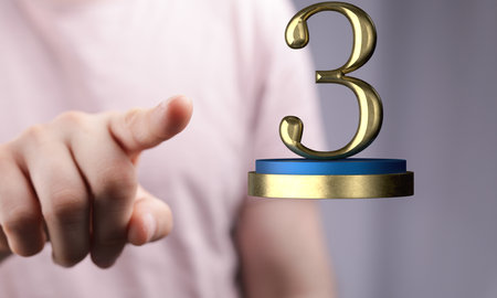 A shallow focus shot of a human hand pointing at third place prize - competition concertの写真素材