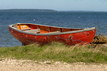 A closeup of a red old boat on the coastの写真素材