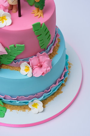 A vertical photo of Moana and flamingo theme layer cake
