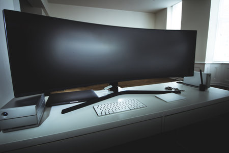 An interior view of an office with a big monitor and a keyboard