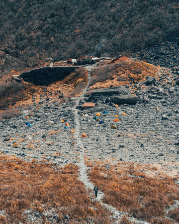A vertical shot of the slope of the mountain with tents.