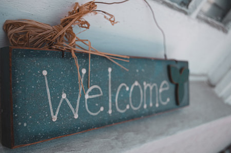 A closeup of a wooden Welcome sign