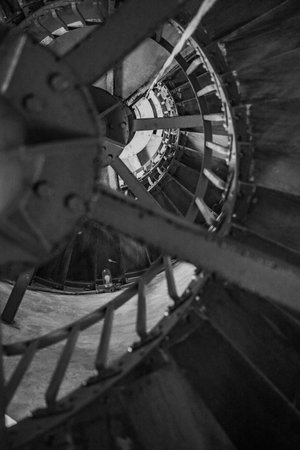 A vertical grayscale shot of a spiraling long staircaseの写真素材