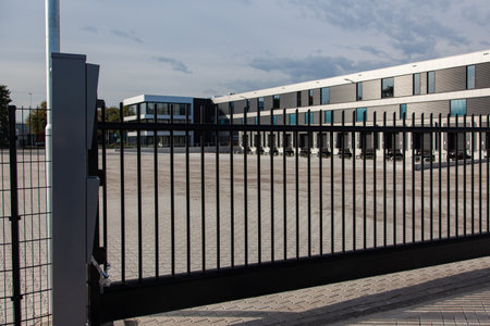 The courtyard of the new warehouse protected by a heavy electric fence on a sunny day