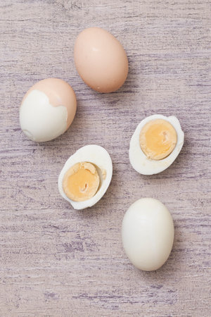 A top view of the boiled eggs cut in pieces on a wooden surface