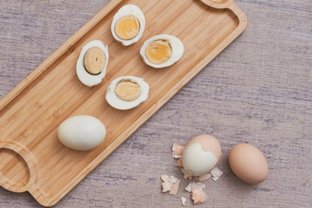 A top view shot of boiled eggs on a wooden board in a kitchenの写真素材
