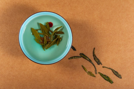 A closeup of a blue bowl and dried herbs on a brown surfaceの写真素材