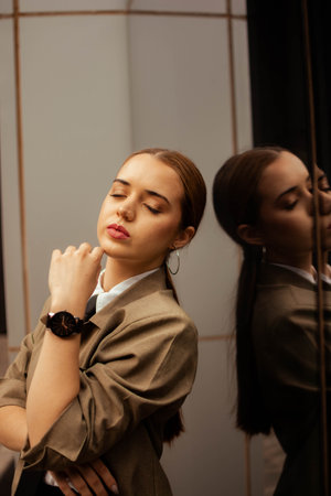 A beautiful young Hispanic girl in business clothing posing near a mirror in Argentinaの写真素材