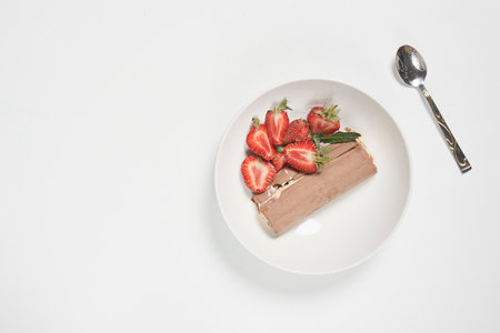 A top view of ripe strawberries and refreshing ice cream sandwich on the plate over the white surfaceの写真素材