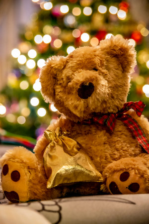 Teddy bear, christmas decorations. Christmas tree as a background. Selective focus.