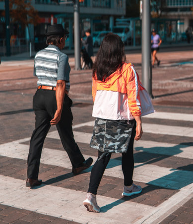 A vertical shot of an old couple crossing a streeの写真素材