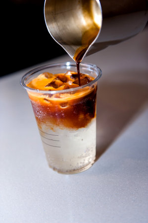 A vertical closeup shot of iced coffee in a cup on a table
