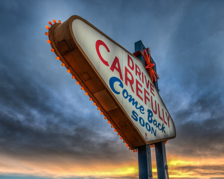 A low angle of drive carefully come back soon Las Vegas Nevada sign against sunsetの写真素材