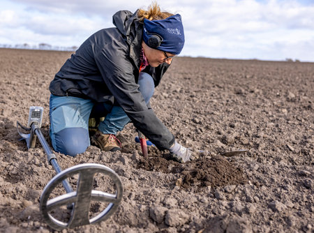Digging in the field to find the metal objectの写真素材