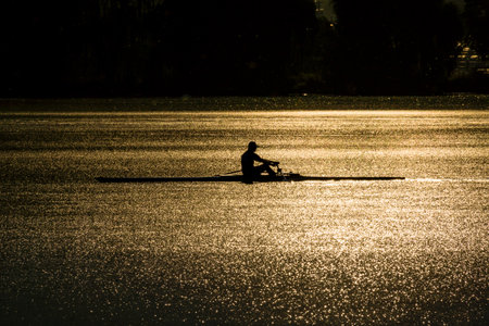 A silhouette of a person kayaking  an intermittent lake during the sunset