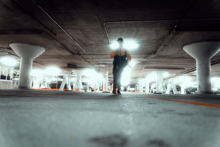 A guy wearing a yellow jacket and a backpack in a parking lotの写真素材