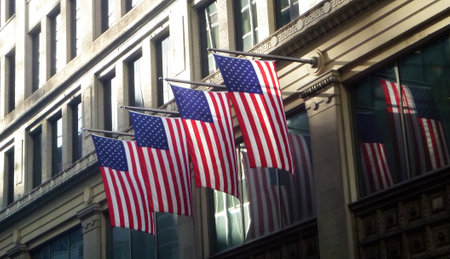 An exterior facade of American flags hanging from the wall of a building