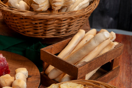 A wooden table with many types of tasty appetizers and freshly baked bread