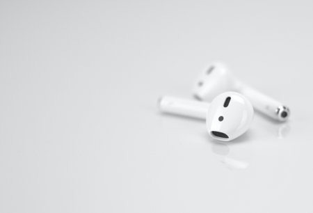 A horizontal selective focus shot of apple AirPods 2 placed on a white table.の写真素材