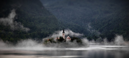A castle on the Bled lake on a foggy morning in Slovenia