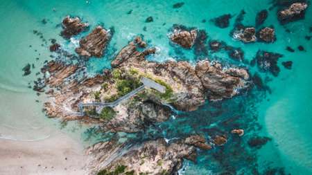 An aerial view of rock formations and crashing waves in the sea