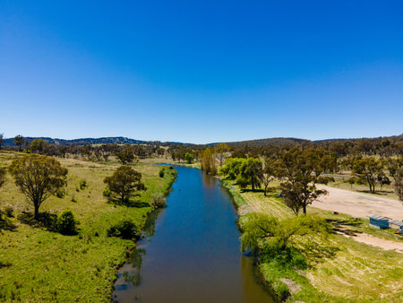A view of a big green field of the Beardy River with beautiful blue sky in Australia and the river